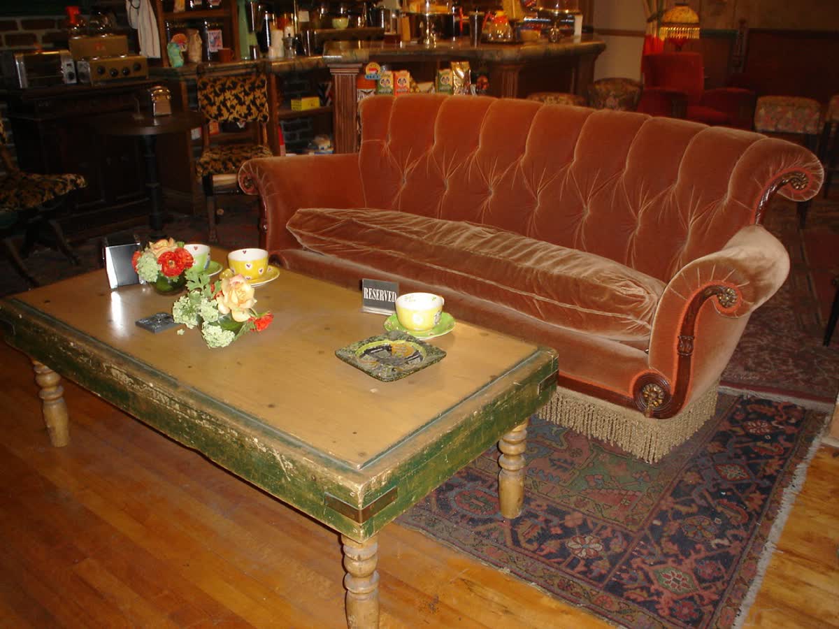 The orange couch at Central Perk, with a coffee table in front of it